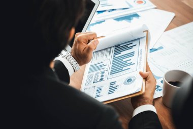 Ofis masasındaki finansal veri raporlarını analiz eden çeşitli bir grup iş analisti. Stratejik pazarlama planlaması için iş zekası analizi çizelgesi ve grafiği.