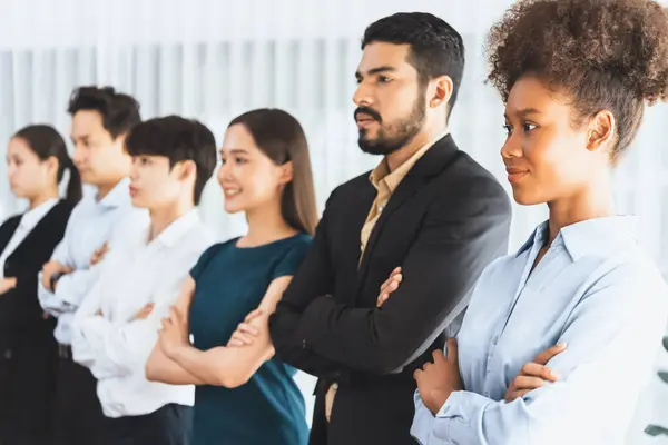 Diverse group of professional business people stand in line with cross arm gesture in modern corporate office. Happy and smiling multiracial office worker team bond and succeed together. Concord