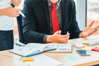 İki iş adamı toplantı odasında proje stratejisi hakkında konuşuyor. İş adamı, iş yerinde iş arkadaşlarıyla proje planlamasını tartışırken aynı zamanda mali raporla ilgili sohbet ve tavsiyelerde bulunuyor. Jivy
