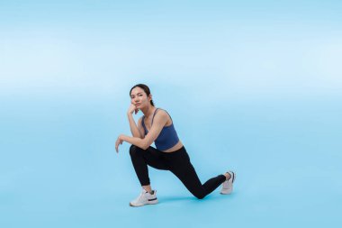 Spor giyimli çekici Asyalı kadın spor egzersizlerinden önce esneme hareketleri yapıyor. Stüdyo çekimlerinde ısınan atletik bir kadınla sağlıklı vücut bakımı egzersizi. Kuvvetli