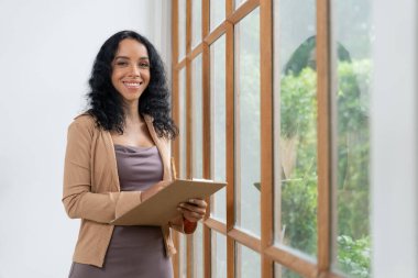 Klinikteki psikolog kadın. Profesyonel portresi. Dostane gülümsemesiyle hastayı psikoloğa davet ediyor. Deneyimli ve kendinden emin psikolog çok önemli bir uzmandır.
