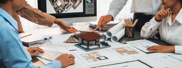 Group of interior architect designer discussing together on blueprint and laptop screen display architecture software for more precise designing layout. Modern home design and renovation. Insight