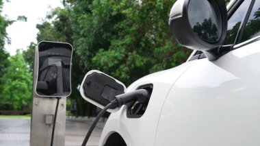 Elektrikli araba parkı ve şarj istasyonunun yanında şarj edilen enerji konseptinin sürdürülebilirliği. Çevresel koruma için yenilenebilir enerji tarafından kullanılan elektrikli araç.