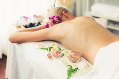 Lüks spa salonlarında sıcak mum ışığında cilt bakımı yaptıran kadın müşteri. Sağlık Spa vücut fırçasında tuz temizleme güzellik tedavisi. Sessiz.