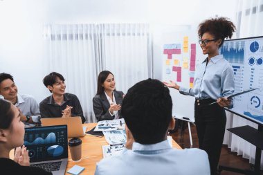 Genç Afrikalı iş kadını modern toplantıda TV ekranında veri analizi paneli sunuyor. Bir grup iş adamıyla konferans odasında iş sunumu. Uyum