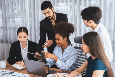 Çok ırklı analist ekibi toplantı masasındaki mali raporu analiz etmek için BI gösterge tablosunu kullanıyor. Çeşitli iş adamlarından oluşan bir grup, FIntech 'in veri analizini başarılı iş pazarlaması için kullanır. Uyum