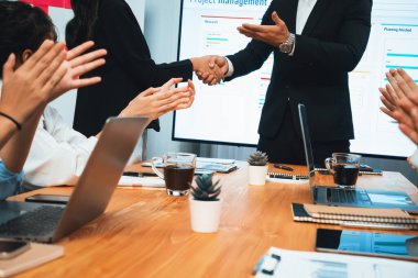 Neşeli toplantı odası, iş adamları el sıkışarak kutluyor. Başarılı proje son teslim tarihinden önce tamamlandı. İş ortaklığı ve proje yönetiminde işbirliği. Habiliment