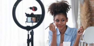 Kadın nüfuzlu kişi canlı yayında video görüntülerini çekiyor. Makyaj çok önemli sosyal medya ya da blog. Kozmetik stüdyosu ışıklandırmalı mutlu genç kız çevrimiçi pazarlama oturumu yayını için..