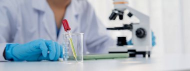 Laboratuvar araştırmacısı laboratuvar tüpünde kimyasal sıvı kullanarak yeni ilaç ya da tedavi geliştirir. Laboratuvar ekipmanları ile bilimsel uzmanlık ile sağlık hizmetlerinin teknolojik gelişimi. Panorama Katı