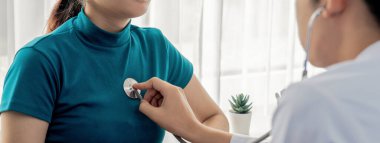 Hasta klinikte ya da hastane ofisinde doktor randevusuna gidiyor. Hastaların nabzını steteskopla kontrol ederken, doktor semptomları muayene ediyor ve teşhis ediyor. Panorama Katı