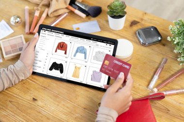 İnternet pazarından alışveriş yapan kadın modern yaşam tarzı için satış malzemeleri arıyor ve önemli siber güvenlik yazılımları tarafından korunan cüzdandan çevrimiçi ödeme için kredi kartı kullanıyor