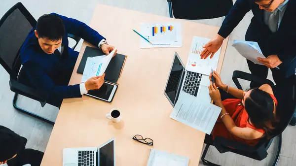 İş adamları grup toplantısı ofiste yukarıdan çekildi. İş kadınları, iş adamları ve ofis çalışanları toplantı masasında proje planlama belgeleriyle takım konferansında çalışıyorlar. Jivy