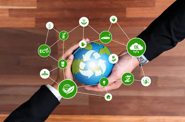 Business partnership holding Earth globe together with recycle icon symbolize ESG sustainable environment and ecosystem protection with eco technology and waste recycling management. Reliance