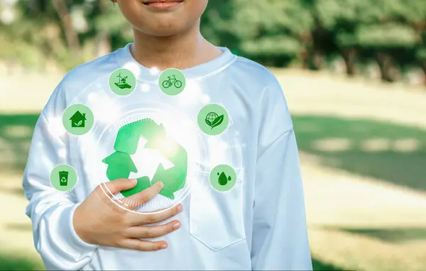 Green recycle symbol for environmental sustainability and natural protection awareness campaign with blurred little boy promoting recyclable ESG practice at outdoor park background. Reliance