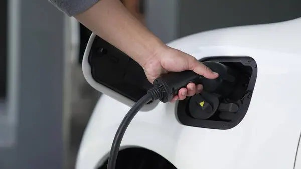 Fortschrittlicher Mann Befestigt Einen Emissionsfreien Stromanschluss Der Batterie Eines Elektrofahrzeugs — Stockfoto