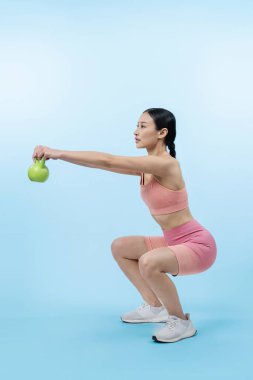 Dinç, enerjik bir kadın izole edilmiş arka planda ağırlık kaldırma egzersizi yapıyor. Genç atletik Asyalı kadın dayanıklılığı ve dayanıklılık eğitimi rutin vücut egzersizi..