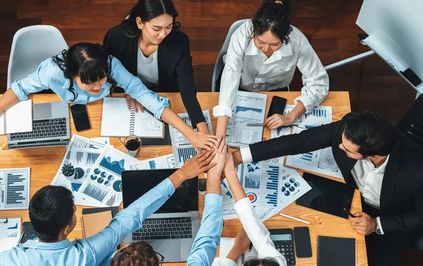 Multiracial business people make synergy hand stack together in meeting room as cooperation or team building for corporate employee in workplace. Top view. Meticulous