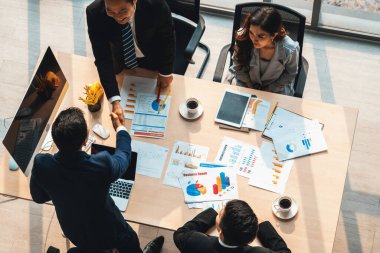 Grup iş adamları toplantı masasında el sıkışırken üst açıdan kendilerine güvenirler. Genç işadamı ve işkadını işçiler yatırım anlaşması imzaladılar. Jivy