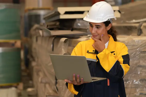 女性エンジニアまたは工場検査官は 金属鋼材の在庫チェックと品質管理を実施し 重工業の出力最適化と製造安全に貢献しています 実行する — ストック写真