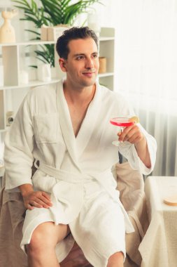 Güzellik ya da vücut bakımı güzellik salonu yaşam tarzı konsepti. Lüks otel kaplıcalarında ya da dinlenme odasında bornoz giyen bir adam. Tatil ve boş zaman rahatlığı. Sessiz.