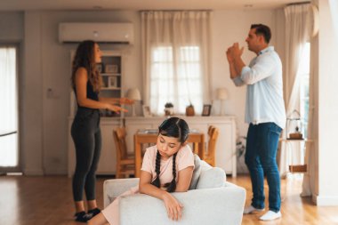 Sinirli ve mutsuz genç bir kız oturma odasında ebeveyninin tartışması yüzünden gerginliğin ortasında kanepede oturuyor. Sağlıksız ev hayatı ve travmatik çocukluk depresyona dönüşür.
