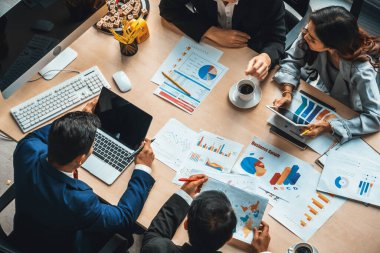 İş adamları grup toplantısı ofiste yukarıdan çekildi. İş kadınları, iş adamları ve ofis çalışanları toplantı masasında proje planlama belgeleriyle takım konferansında çalışıyorlar. Jivy