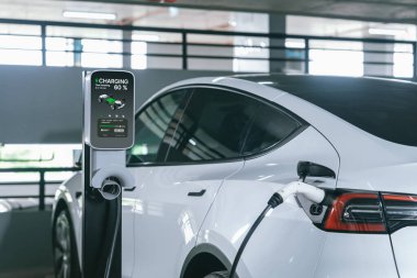 Alış veriş merkezinin otoparkında EV elektrikli araba şarjı şehir merkezindeki sürdürülebilirlik yaşam tarzını yeşil, temiz, yeniden şarj edilebilir elektrikli araç iç organları ile gösteriyor.