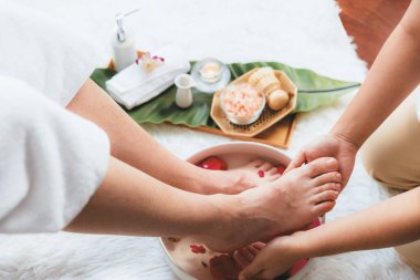 Adam lüks kaplıcalarda mutlu ayak masajına devam ederken, masör de hafif gün ışığı atmosferinde refleksoloji terapisi ya da otel ayak spa 'sında. Sessiz.