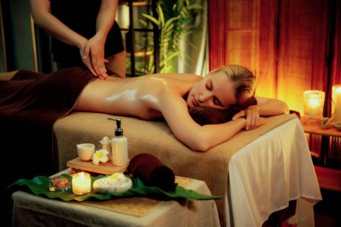 Beyaz kadın müşteri stres önleyici spa masajının keyfini çıkarıyor ve lüks otel ya da otelde sıcak mum ışığında güzellik teniyle eğleniyor. Sessiz.