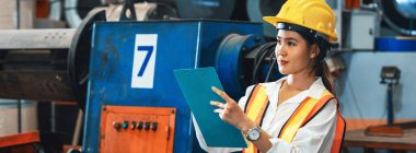 Metal fabrikası teftişi, güvenlik ekipmanlı kadın mühendis müfettişi ağır sanayi inşaatı için tesiste metal malzemesi üzerinde kalite kontrolü yapıyor. Örnek gösteriliyor