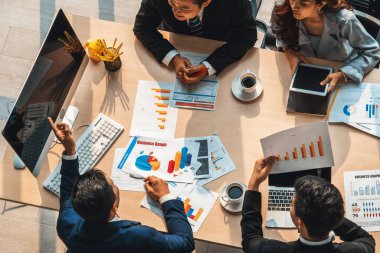 İş adamları grup toplantısı ofiste yukarıdan çekildi. İş kadınları, iş adamları ve ofis çalışanları toplantı masasında proje planlama belgeleriyle takım konferansında çalışıyorlar. Jivy