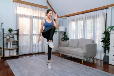 Enerjik ve güçlü atletik Asyalı kadın evinde koşuyor. Formda fiziğin takibi ve ev çalışması ve eğitimle sağlıklı yaşam tarzına bağlılık. Kuvvetli