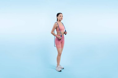 Spor giyim sektöründe genç enerjik Asyalı kadın atlıyor ya da atlıyor stüdyo çekimlerinde izole edilmiş arka planda portre pozu veriyor. Kardiyo egzersiz aleti ve sağlıklı vücut bakımı yaşam tarzı. Kuvvetli