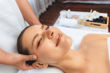 Kafkasyalı kadın stres önleyici kafa masajından ve lüks tatil beldesi ya da otel spa salonundaki modern ışık ortamında yüz güzelliği eğlencelerini şımartmaktan hoşlanıyor. Sessiz.