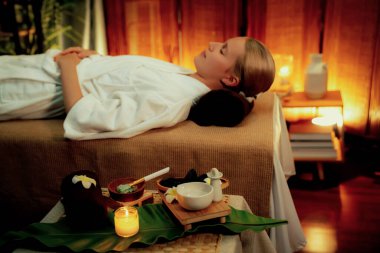 Aromaterapi masajı ambiyansı ya da spa salonu kompozisyon düzeneği bulanık kadınlara odaklı dekor mumları ve spa aksesuarları ile tatil köyü veya otel arka planında keyifli aroma spa masajı yapan. Sessiz.