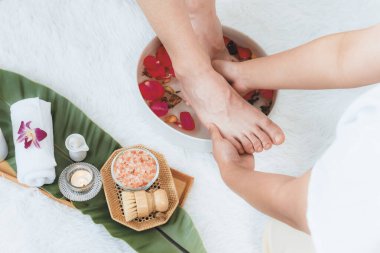 Kadınlar lüks spa salonlarında keyifli ayak masajlarına devam ederken, masör de hafif gün ışığı atmosferinde refleksoloji terapisi veya otel ayak spa 'sında. Sessiz.