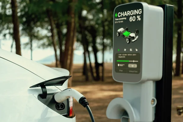 Electric car recharging battery at outdoor EV charging station for road trip or car traveling by the seascape beach, alternative and sustainable energy technology for eco-friendly car. Perpetual