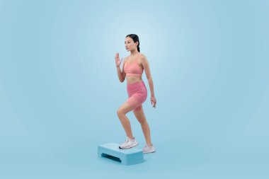 Çalışkan, enerjik bir kadın atölyede egzersiz yapıyor. Kardiyo aerobik hareketleriyle izole bir arka plan. Genç atletik Asyalı kadın mahareti ve dayanıklılık eğitimi konsepti.