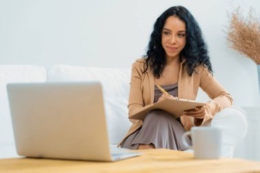 İnternette önemli bir iş için dizüstü bilgisayar kullanan Afro-Amerikalı bir kadın. Evde çalışan sekreter veya çevrimiçi içerik yazma.