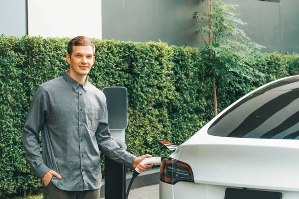 Junger Mann Reist Mit Elektroauto Aufladung Grünen Nachhaltigen Stadtgarten Sommer — Stockfoto