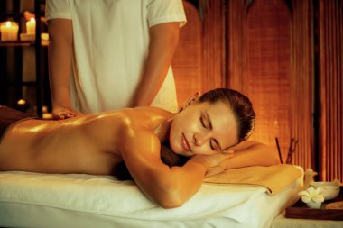 Beyaz kadın müşteri stres önleyici spa masajının keyfini çıkarıyor ve lüks otel ya da otelde sıcak mum ışığında güzellik teniyle eğleniyor. Sessiz.