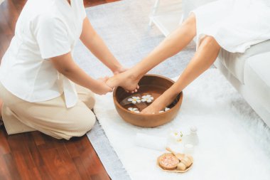 Kadınlar lüks spa salonlarında keyifli ayak masajlarına devam ederken, masör de hafif gün ışığı atmosferinde refleksoloji terapisi veya otel ayak spa 'sında. Sessiz.