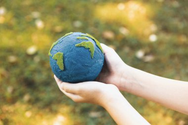 Dünya gezegenini ESG ilkesi ve çevre dostu enerjisiyle daha parlak bir gelecek için Dünya günü olarak el ele tutuşan genç çocuklar. Döngü