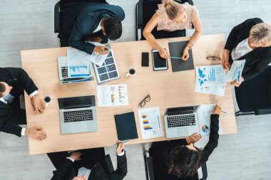 İş adamları grup toplantısı ofiste yukarıdan çekildi. İş kadınları, iş adamları ve ofis çalışanları toplantı masasında proje planlama belgeleriyle takım konferansında çalışıyorlar. Jivy