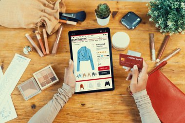 İnternet pazarından alışveriş yapan kadın modern yaşam tarzı için satış malzemeleri arıyor ve önemli siber güvenlik yazılımları tarafından korunan cüzdandan çevrimiçi ödeme için kredi kartı kullanıyor