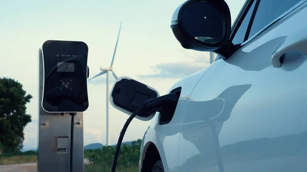 利用风力涡轮机提供绿色和可再生能源的充电站为电动汽车充电 以保护环境 — 图库照片