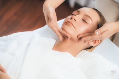 Kafkasyalı kadın stres önleyici kafa masajından ve lüks tatil beldesi ya da otel spa salonundaki modern ışık ortamında yüz güzelliği eğlencelerini şımartmaktan hoşlanıyor. Sessiz.