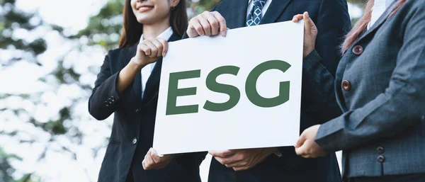 Group of business people stand united, holding eco-friendly idea and concept for environmental awareness campaign and embracing ESG principle for greener environment and sustainable future. Gyre
