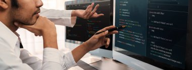 Yazılım geliştirme ekibi ofiste birlikte çalışıyor, bilgisayar ekranında betik görüntülemesi kodluyor. Teknoloji geliştirici şirketinde çalışan programcı ve yazılım mühendisi. Önde.