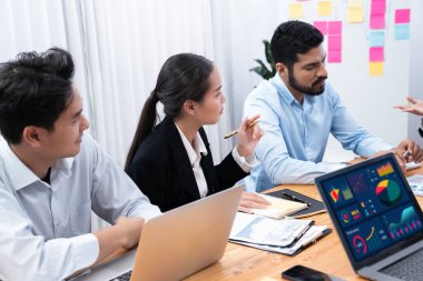 Çok ırklı analist ekibi toplantı masasındaki finansal verileri analiz etmek için BI Fintech yazılımı kullanıyor. Finansal konsol veri ekranında pazarlama göstergesi için analiz edilmiş grafikle birlikte. Uyum